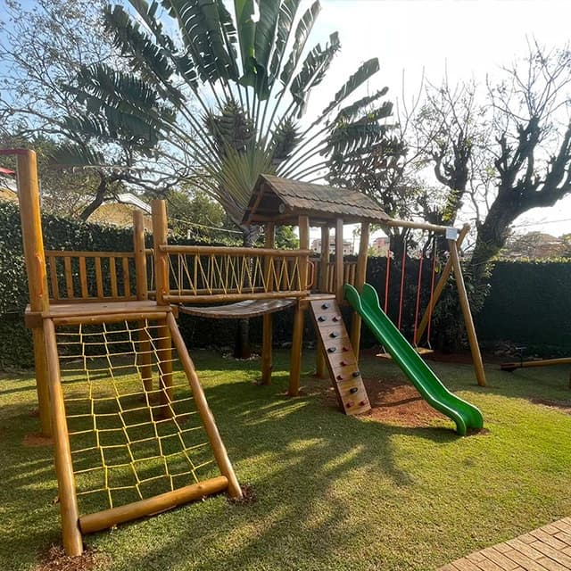 Parque de madeira com escorregador e rede de escalada